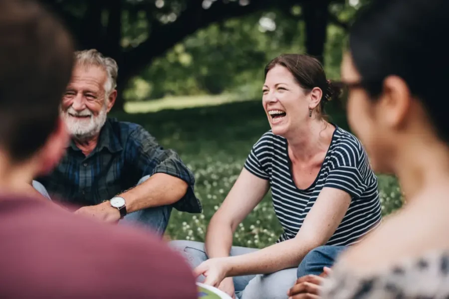 people talking in a circle sitting on grass